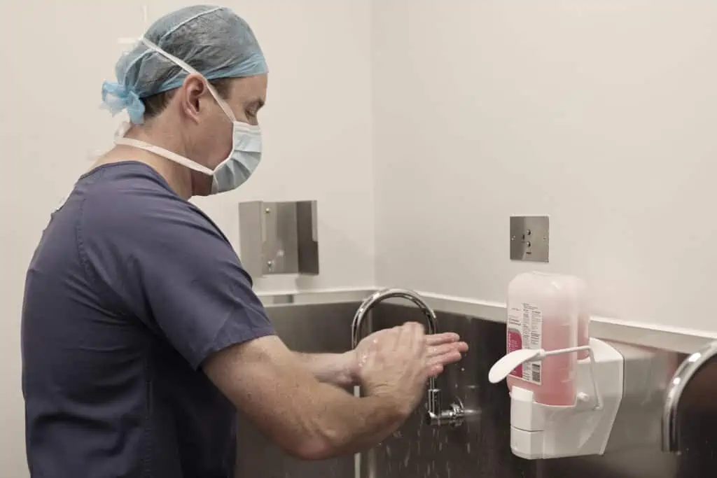 Dr Ben Lancashire washing his hands in preparation for surgery